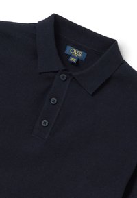 Marineblauwe polo met een gebreide textuur, voorzien van een opgevouwen kraag en drie zwarte knopen op de sluiting. OVS kids-label aan de binnenkant van de kraag.