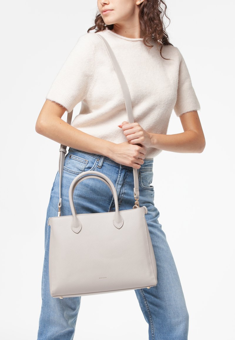 Borsa a tracolla in pelle grigia chiara con due manici superiori e una tracolla removibile. Texture liscia, forma strutturata e dettaglio logo discreto.