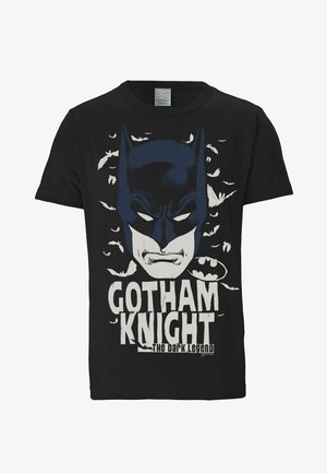 Black cotton t-shirt featuring a graphic of a Batman face with white bats and the text "Gotham Knight" in distressed lettering below.