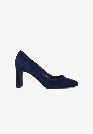 Marineblauwe suede hoge hak pump met een puntige neus en een dikke hak. Gladde textuur met een strakke, minimalistische uitstraling.