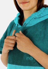 Türkisfarbener Kapuzenponcho aus Frottee, mit einer Kordelzugkapuze und einem kontrastierenden helleren Tealstreifen am unteren Rand.