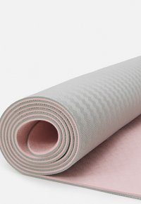 Rullitud jooga matt, millel on tekstureeritud hall pind ja roosa aluspind. Kujundus sisaldab peeneid mustreid ja ümarate servadega.