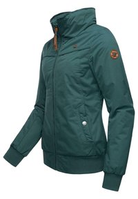 Veste zippée teal avec un col haut, des poignets côtelés et une taille côtelée. Présente un patch logo sur la manche et une poche latérale avec un bouton de fermeture.