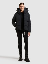 Svart vadderad jacka med huva, med dragkedjestängning, sidofickor och ett quiltat mönster. Matchas med svarta leggings och snörstövlar.
