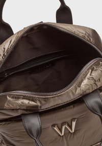 Sac à dos en nylon vert olive avec poignées en cuir noir, fermeture éclair, et un intérieur noir doté d'une poche zippée. Accent en or "W".