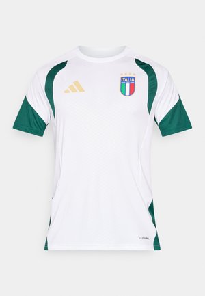 Camiseta deportiva blanca con detalles verdes en los hombros, tejido texturizado y un escudo de Italia en azul, verde y rojo con estrellas doradas.