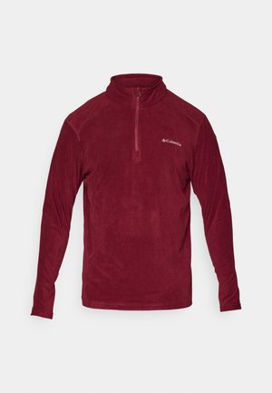Bordeaux fleece pullover med høj krave, halvlukning, lange ærmer og et logo på venstre bryst. Blød tekstur, afslappet design.