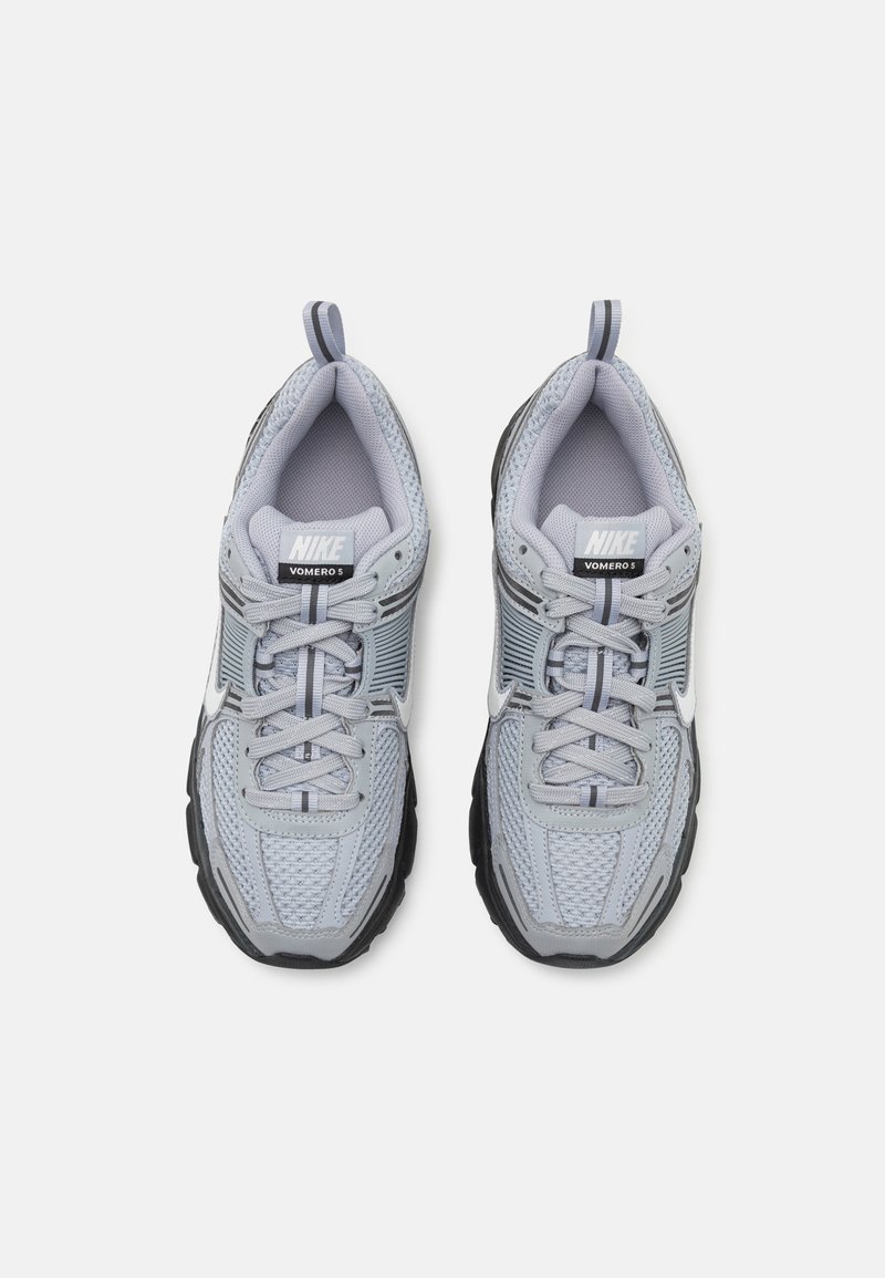 Graue Nike Vomero 5 Laufschuhe mit einem Obermaterial aus Mesh, gepolsterter Schuhzunge, schwarzem Gummi-Außensohle und reflektierenden Akzenten. Schnürsenkel und Zuglasche sind enthalten.