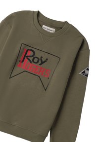 Felpa verde oliva con il logo "Roy Roger's" in nero e rosso sul petto e una toppa nera sul manica sinistra.