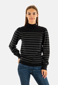 Zwart gebreid vest met grijze horizontale strepen, een hoge hals en pofmouwen. Heeft decoratieve knopen op de schouder.