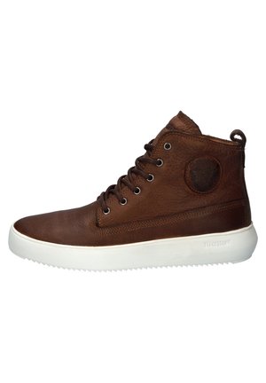Zapatilla alta marrón hecha de cuero con un acabado texturizado, suela de goma blanca y parche con logo circular en el lateral. Diseño con cordones.