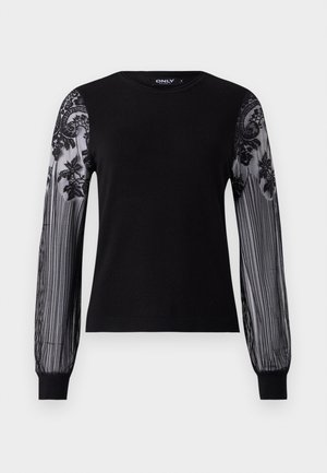 Svart långärmad topp med en solid stickad kropp och genomskinliga, strukturerade meshärmar som har blommig broderi och randig mönstring vid manschetterna.