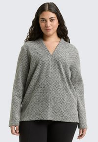 Gray patterned long-sleeve top with a V-neck, loose fit, and textured fabric. The design features a geometric pattern throughout.