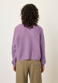 Lila fluffige trui met verlaagde schouders, geribbelde manchetten en een cropped zoom, gecombineerd met beige gestructureerde wijde broek.