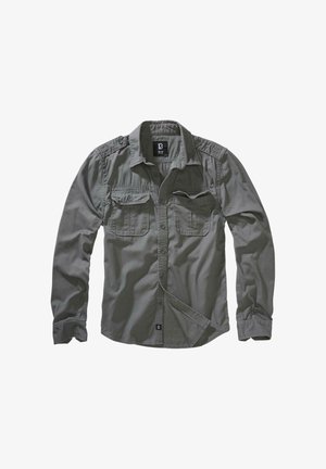 Szürke hosszú ujjú ing könnyű anyagból. Gombos elülső része, két mellzsebe és vállpántjai vannak.