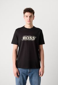 T-shirt en coton noir arborant un logo blanc audacieux avec le mot "BOSS" sur la poitrine, à manches courtes et avec un col rond classique.