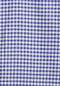 Μικρό καρό ύφασμα σε μπλε και λευκό με ομοιόμορφα διατεταγμένα τετράγωνα που σχηματίζουν ένα πλέγμα σε όλο το υλικό.