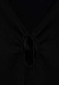 Black sweater with a wide V-neck featuring gathered fabric and a center tie detail, showcasing smooth texture and a snug fit.