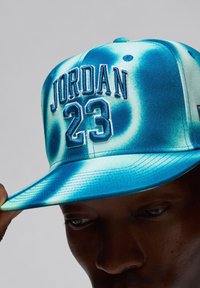 Cappellino blu e turchese con ricamo "JORDAN" e "23" sul fronte, con un design strutturato e visiera piatta.