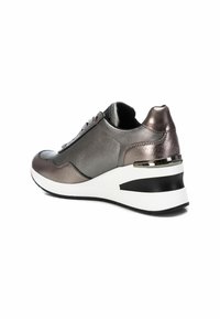 Zapatilla gris metálica con textura de cuero suave, parte frontal con cordones, cuello acolchado y suela blanca elevada con una franja de acento negra.
