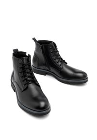 Czarne skórzane botki za kostkę o teksturowanym wykończeniu, z sznurówkami, bocznym zamkiem błyskawicznym i kontrastującą niebieską podeszwą.