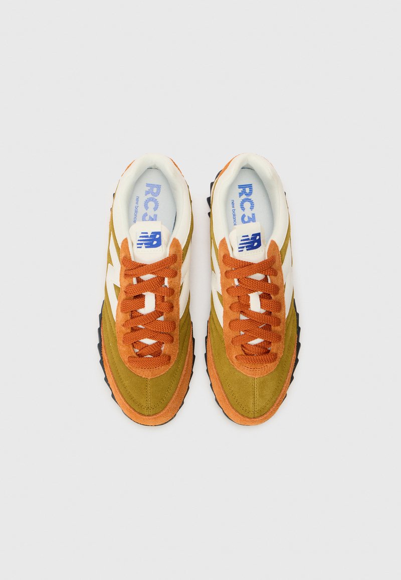 Zapatillas New Balance que presentan una combinación de ante verde y naranja con acentos en blanco, cordones texturizados y una suela de goma negra.