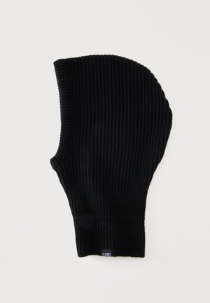 Cagoule noire en maille côtelée avec une petite étiquette noir et blanc en bas, présentée à plat sur fond blanc.