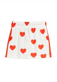 Witte rok met rode hartpatronen, elastische tailleband en rode accenten aan de zijkanten. Gemaakt van zachte stof met een gladde textuur.