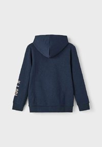 Felpa blu navy con tasca a marsupio, polsini e orlo a coste. Presenta un cappuccio e la scritta "just fit" stampata sulla manica sinistra in un colore chiaro.