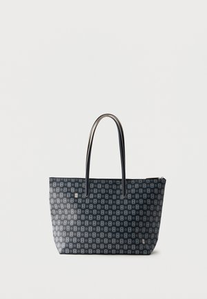 Bolsa tote negra con patrón geométrico gris claro repetido y dos asas delgadas, de pie sobre un fondo blanco.