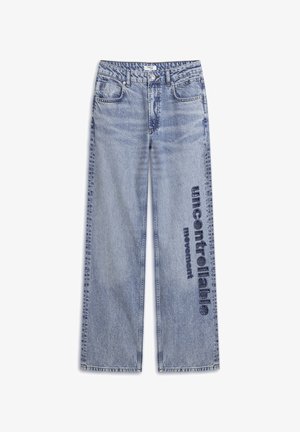 Helle blaue Jeans mit weitem Bein. Gefeaturet ist eine ausgewaschene Optik und der Text "unkontrollierbare Bewegung" in dunkelblau auf dem Bein aufgedruckt.