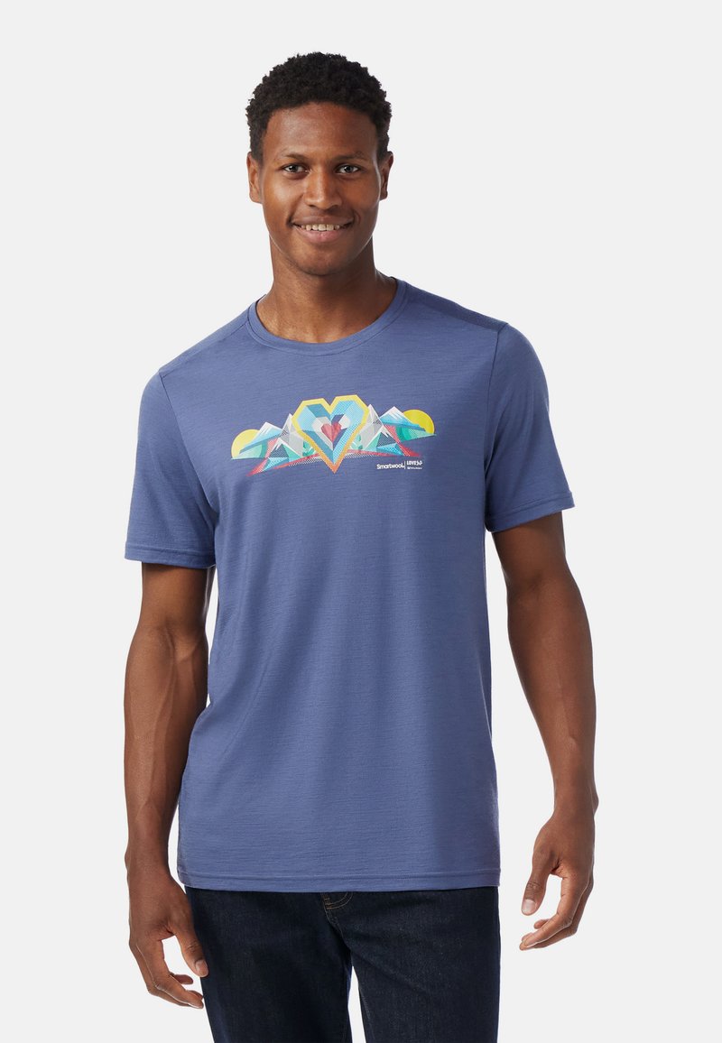 Camiseta de hombre de manga corta, de tela azul, con cuello redondo, que presenta un diseño gráfico de un corazón montañés multicolor en el frente. Textura suave.