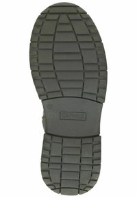 Suela de zapato de goma negra con un patrón de tracción estriada, que presenta un diseño ovalado central y el nombre de la marca "CAPRICE" grabado en la superficie.