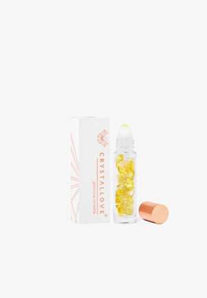 Heldere glazen rollerballfles met gele kristalachtige parels, gouden rolopdracht en witte doos gemerkt met "CRYSTALLOVE" in oranje tekst.