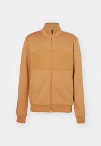 Giacca con chiusura lampo color beige con collo alla coreana, caratterizzata da un design a pannelli a contrasto, polsini a coste e una finitura in tessuto liscia.