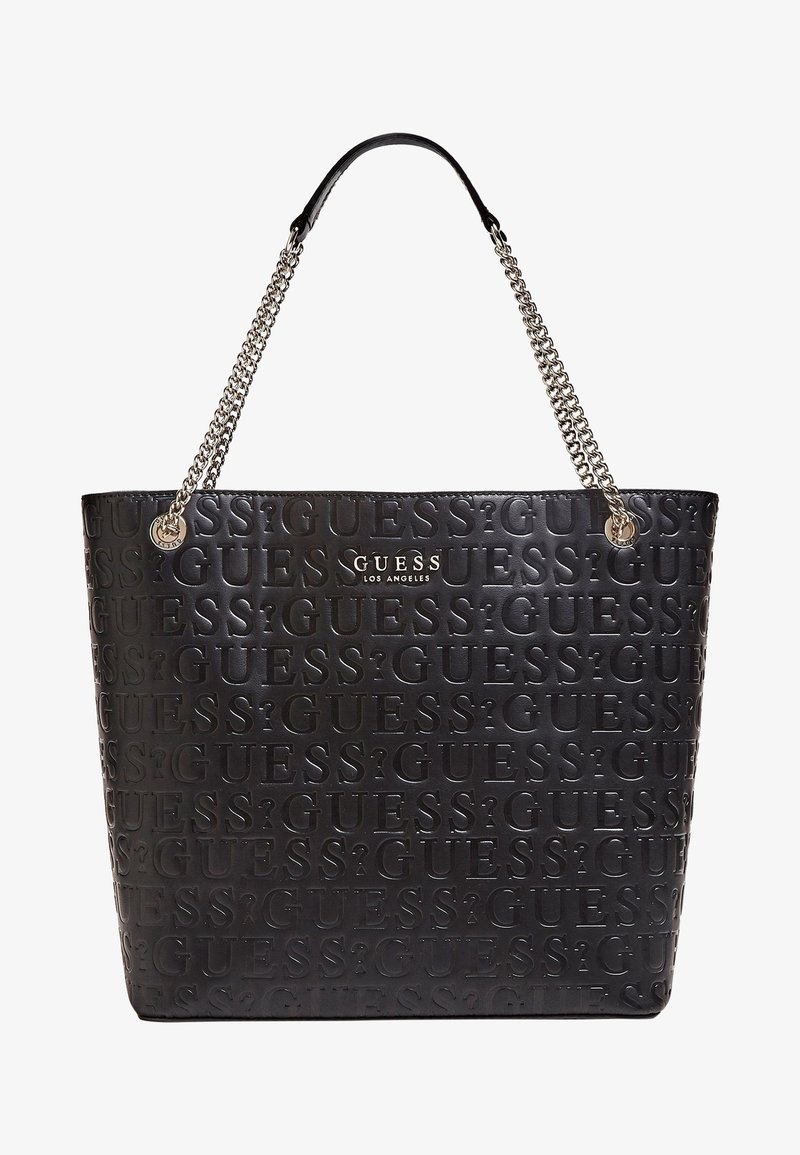 Sac cabas en cuir noir de la marque Guess, embossé avec le texte "GUESS?" répété, anses en chaîne argentée, et logo argenté "GUESS Los Angeles" au centre devant.