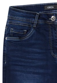 Jean en denim bleu foncé à texture lisse, doté d'une fermeture par boutons, de coutures jaunes contrastantes et d'une petite poche avant.