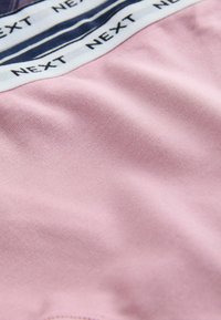 Material roz din bumbac, cu textură netedă, având o talie albă cu dungi bleumarin și textul "NEXT" repetat.