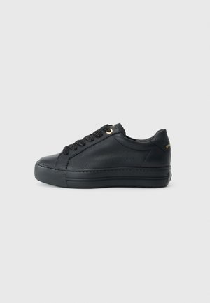 Black low-top sneaker made of textured leather, featuring a rubber sole, black laces, and a gold accent on the side.