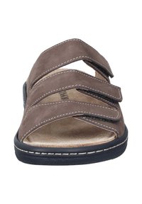 Braune Sandale mit drei verstellbaren Klettverschlüssen, glatter Wildledertextur, gepolsterter Fußbettung und schwarzer Gummisohle mit weißer Naht.