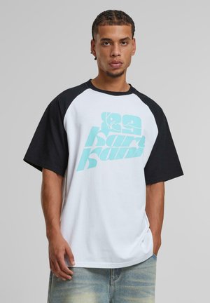 White and black raglan t-shirt with turquoise graphic design, featuring a relaxed fit, short sleeves, and soft cotton texture.