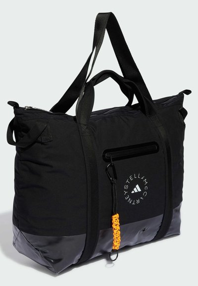 Sac de sport noir avec un fond imperméable, deux anses noires, un logo et un accent tressé orange sur une boucle latérale. Fermeture zippée en haut.