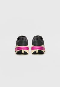Sport shoes in black mesh with pink accents; cushioned soles with a textured finish. Features rounded heel and contrasting outsole design.