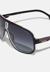 Prillid halli gradient objektiiviga, mustast plastikust raamiga, hõbedaste aktsentidega ja punase triibuga detailideks. Tekst näitab "CARRERA UV PROTECT."