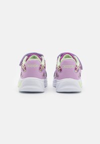 Lila och vita sneakers med en texturerad finish, med ett kardborreband och färgglada detaljer på klackarna och sidorna.