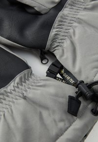 GANT GORE-TEX avec un tissu gris et des accents en cuir noir. Inclut une sangle ajustable et une surface texturée pour une meilleure prise et chaleur.