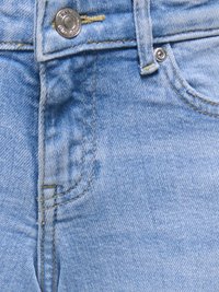 Jean en denim bleu clair en gros plan, montrant un bouton en métal, une passoire de ceinture, une poche avant et des détails de double couture.