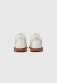 Sneaker bianche con accenti azzurri, tomaia in mesh testurizzato e suola in gomma marrone. Presentano il logo sul tallone e un collare imbottito.