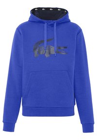 Felpa blu realizzata in morbido tessuto, con una grafica di coccodrillo nera, tasca a marsupio e rivestimento interno della cappuccio a contrasto con un motivo di coccodrillo.