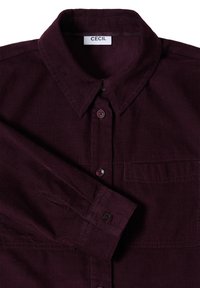 Bordeaux fløjlsskjorte med knaplukning, krave, brystlomme og sorte knapper, og med fine lodrette ribber i stoffet.